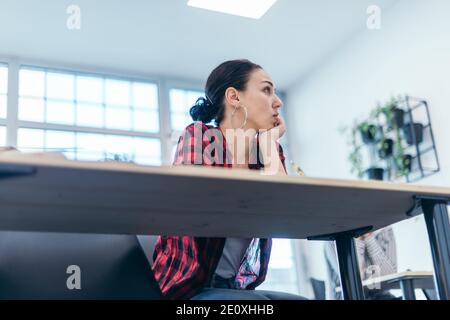 Multiethnische Geschäftsgruppe, die einem Redner zuhört, während sie an einem Geschäftsseminar in einem modernen Workshop teilnimmt. Stockfoto