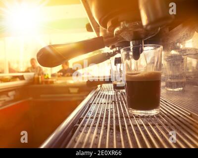 Glas Tasse mit Kaffee in einer Espressomaschine in EINEM Bar Stockfoto