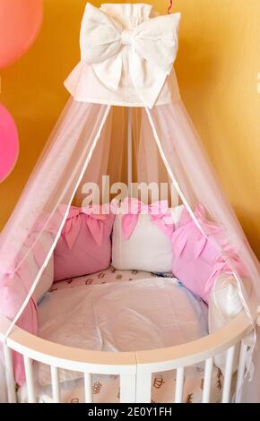 Das Bett des Mädchens in der Ecke des Zimmers ist mit Luftballons dekoriert. Stockfoto