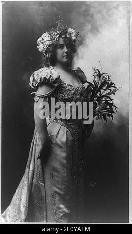 Lillian Russell, drei viertel länge Portrait, stehend, nach rechts, mit Blumen Stockfoto