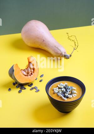 Kürbiscremesuppe mit rohen Kürbissen und Samen. Stockfoto