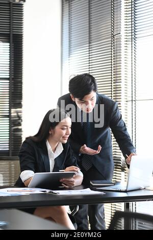 Bild von Geschäftsleuten, die im modernen Büro zusammenarbeiten und durch neue Ideen sprechen. Stockfoto