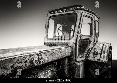 Alte rostig gebrochen ländlichen Traktor steht im Hinterhof. Schwarzweiß-Foto. Stockfoto