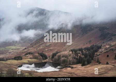 Schöne Landschaft Winter Sonnenaufgang Blick auf Blea Tarn von der Seite Pike in Lake District mit niedrigen Wolken über Berg Oberteile Stockfoto