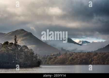 Episches Landschaftsbild mit Blick über Derwentwater im Lake District Catbells schneebedeckter Berg mit dichtem Nebel Rollen durch Tal Stockfoto