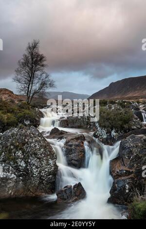 Atemberaubende Landschaftsaufnahme des Buachaille Etive Mor Wasserfalls in Scottish hochland an einem Wintermorgen mit langer Belichtung für glatt Fließendes Wasser Stockfoto