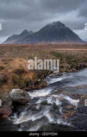 Episches dramatisches Landschaftsbild von Buachaille Etive Mor und River Etive in schottischen Highlands an einem Wintermorgen mit launisch Himmel und Beleuchtung Stockfoto