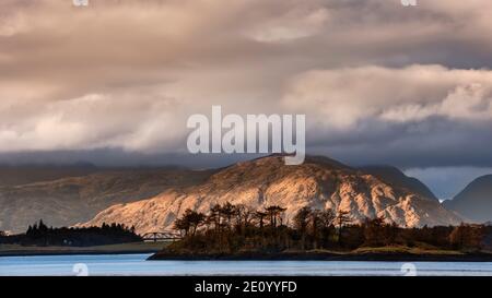 Schönes weiches Licht Landschaftsbild von Loch Leven in Scottish Highlands mit leuchtendem Abendlicht auf Fjälls in der Ferne Stockfoto