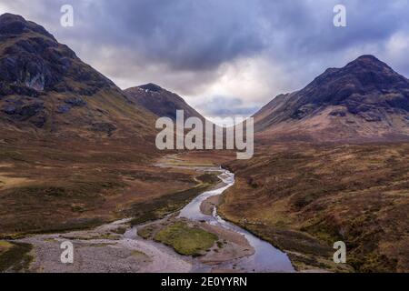 Fliegende Drohne dramatisches Landschaftsbild von Buachaille Etive Mor und Berge und Täler in Schottischen Highlands im Winter Tag Stockfoto