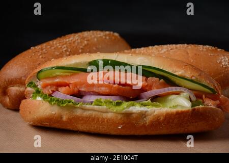 Baguette Sub Sandwich mit Lachsfisch, Zwiebeln, Gurken, Salat Stockfoto