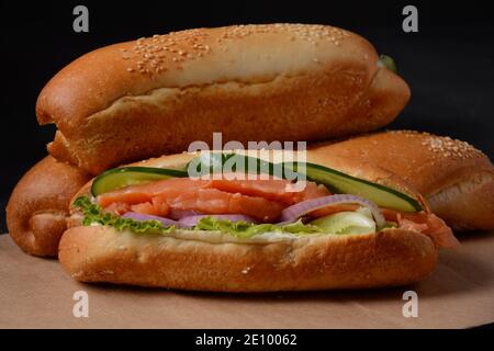 Baguette Sub Sandwich mit Lachsfisch, Zwiebeln, Gurken, Salat Stockfoto