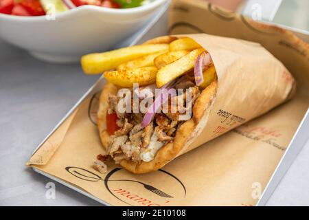 Griechische Gyros in Pita-Brote in einem Papiertaschentuch auf einem silbernen Metalltablett eingewickelt Stockfoto
