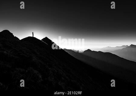 Bergsteiger auf Gipfelgrat mit Hintergrundbeleuchtung, im Hintergrund Ammergauer Alpen, Reutte, Ammergauer Alpen, Tirol, Österreich, Europa Stockfoto