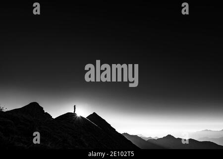 Bergsteiger auf Gipfelgrat mit Hintergrundbeleuchtung, im Hintergrund Ammergauer Alpen, Reutte, Ammergauer Alpen, Tirol, Österreich, Europa Stockfoto