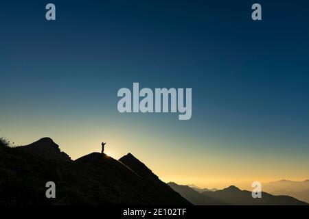 Bergsteiger auf Gipfelgrat mit Hintergrundbeleuchtung, im Hintergrund Ammergauer Alpen, Reutte, Ammergauer Alpen, Tirol, Österreich, Europa Stockfoto