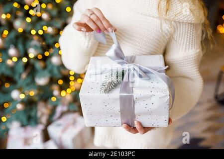 Woman's Händen halten Weihnachten oder Neujahr gestalteten Geschenkverpackung Stockfoto