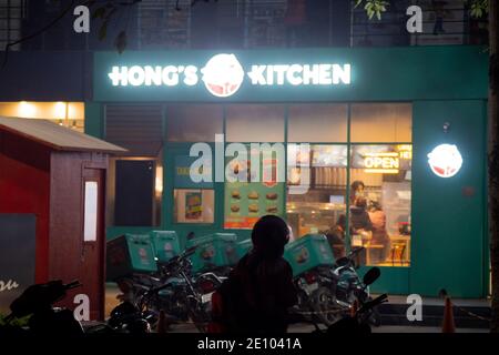 Beleuchtete hongs Küche Schaufenster von jubiliant in der Nacht mit Lieferung Männer stehen in Indien für Mahlzeiten zum Mitnehmen bereit Stockfoto