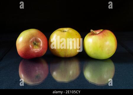 Der reife Apfel zum Ausruhen auf dem Tisch mit Reflexion. Produkte der Fütterung auf schwarzem Hintergrund Stockfoto