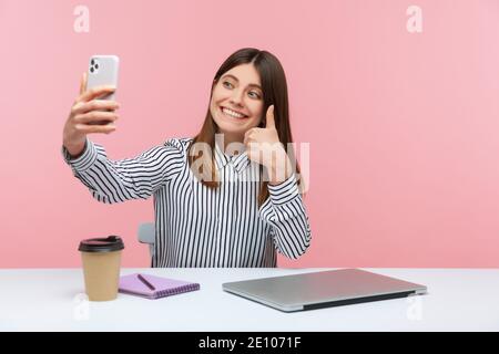 Glücklich positive Frau Blogger zeigt Daumen nach oben wie Geste Aufnahme Video für ihre Abonnenten, geben Empfehlungen sitzen im Home Office. Innen Stockfoto