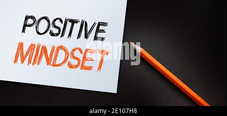 Positiv denkender Text auf Papier und orangefarbenem Bleistift geschrieben. Lifestyle-Geschäftskonzept. Stockfoto