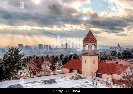 Verschneite Dachterrasse mit Glockenturm einer Kirche mit Salz Blick auf den See City im Hintergrund Stockfoto