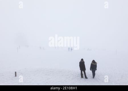 Oberried, Deutschland. Januar 2021. Menschen stehen im dichten Nebel nahe dem Gipfel des Schauinslands. Viele nutzen den letzten Tag des langen Neujahrswochenendes für einen Ausflug in den verschneiten Schwarzwald. Quelle: Philipp von Ditfurth/dpa/Alamy Live News Stockfoto