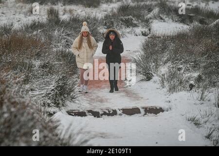 Wanderer steigen den Pfad auf den Gipfel des Pen y Fan, des höchsten Berges von Südwales, bei schneebedeckten Bedingungen auf. Stockfoto