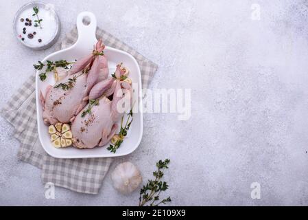 Rohes Wachtelfleisch mit Gewürzen, Knoblauch und Kräutern Stockfoto