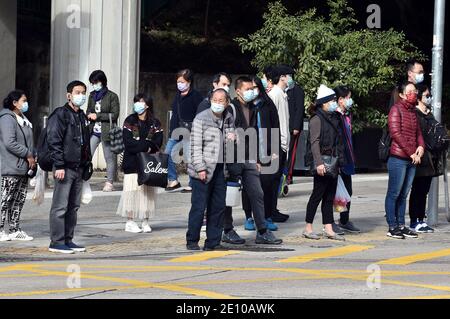 Hongkong, China. Januar 2021. Menschen mit Gesichtsmasken gehen auf einer Straße in Hongkong, Südchina, 3. Januar 2021. Hongkongs Zentrum für Gesundheitsschutz meldete am Sonntag 41 weitere bestätigte Fälle von COVID-19, was sich auf 8,964 annahm. Die neuen Fälle umfassten 40 lokale Infektionen, mit 16 Fällen unbekannter Herkunft. Kredit: Lo Ping Fai/Xinhua/Alamy Live Nachrichten Stockfoto