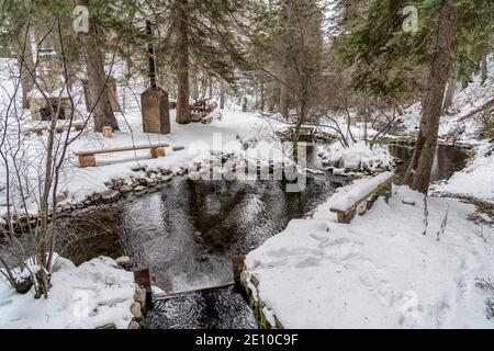Schöner Park in den Bergen mit Bachkaminbänken und Evergreens Stockfoto