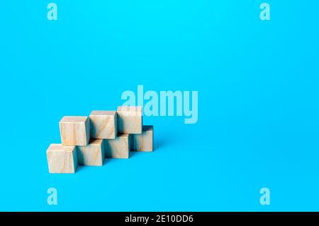 Einfache kubische Form aus Blöcken auf einem blauen Hintergrund montiert. Minimalismus. Einfache Formen Geometrie. Folie für Präsentation. Platz kopieren, für Text platzieren. Stockfoto