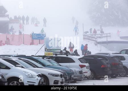 Oberried, Deutschland. Januar 2021. Die Menschen stehen im dichten Nebel in der Nähe des Skilifts am Haldenköpfle, während im Vordergrund der volle Parkplatz der geschlossenen Liftanlage zu sehen ist. Viele nutzen den letzten Tag des langen Neujahrswochenendes für einen Ausflug in den verschneiten Schwarzwald. Quelle: Philipp von Ditfurth/dpa/Alamy Live News Stockfoto