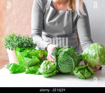 Die Hand einer Frau hält einen grünen Salat in ihren Händen. Stockfoto