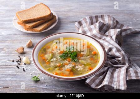 Vegane Suppe mit eingelegten Gurken und Perlgerste, rassolnik. Traditionelle hausgemachte russische Küche. Auf einem Holztisch Stockfoto