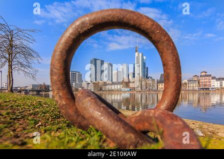 Hochhaus des Finanzviertels in Frankfurt am Main. Blick durch Metallring auf Geschäftsgebäude vom Park entlang der Küste Stockfoto