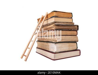 Stapel von alten Büchern und Holzleiter isoliert auf weißem Hintergrund. Stockfoto