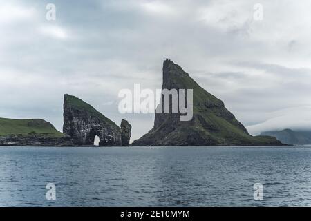 Nahaufnahme der berühmten Drangarnitr Klippe mit den Tindholmur Inseln in Der Hintergrund wurde während der morgendlichen Wanderung im Frühjahr aufgenommen Färöische Küste Stockfoto