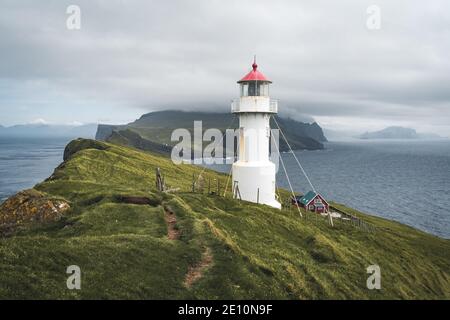 Blick zum Leuchtturm auf der Insel Mykines Holmur, Färöer Insel ein bewölktes Tag mit Blick auf den Atlantik. Stockfoto