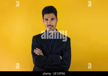 Moderner schwarzer junger Mann in einem Anzug isoliert auf Gelb Schwarzboden Stockfoto