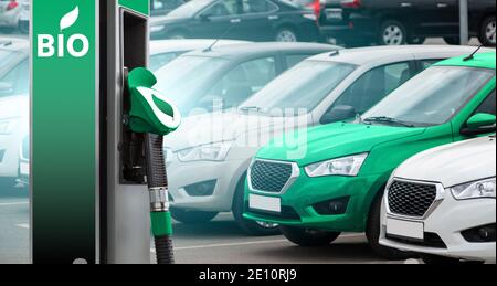 Biokraftstofftankstelle auf dem Hintergrund von Autos. Ein Auto grün. Stockfoto