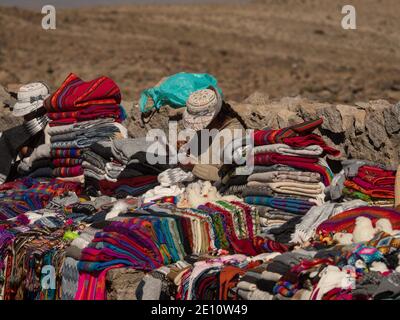 Indigene Frau verkauft traditionelle bunte handgewebte Wolle Textil-Kleidung an Hauptstraße von Colca Canyon nach Arequipa Peru Südamerika Stockfoto