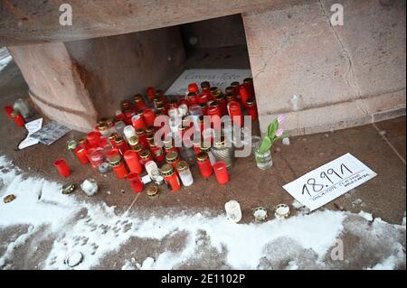 Berlin, Deutschland. Januar 2021. Neben Kerzen am Fuße des Fruchtbarkeitbrunnens am Arnswald-Platz steht eine Notiz, die lautet: "18,991 Ovid-19-Dead on Dec 6, 2020 - Weltkilometerzähler." Quelle: Lisa Ducret/dpa/Alamy Live News Stockfoto