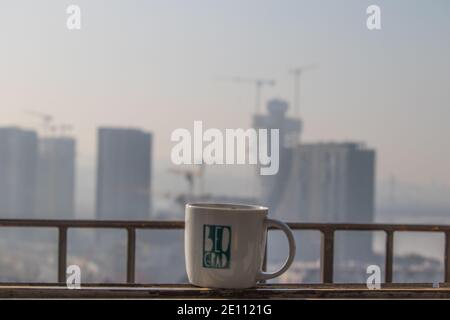 Blick auf den neuen Teil von Belgrad (Hauptstadt von Serbien), der im Bau ist, Belgrad Waterfront, während Sie Morgenkaffee aus einem Becher mit dem Wort Beograd trinken Stockfoto