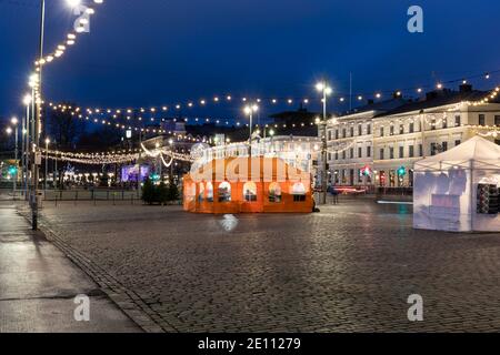 Orangefarbenes Café-Zelt in der Mitte des leeren Marktplatzes nach Einbruch der Dunkelheit in Helsinki, Finnland Stockfoto