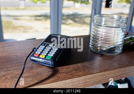 Das Zahlungsterminal für Kreditkarten befindet sich auf dem Tisch im Café des Cafés. Nahaufnahme des kontaktlosen Bezahlgeräts, des Kartenautomaten Stockfoto