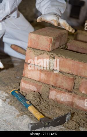 Craftsman Builds Brick Wall - Nahaufnahme Maurer Stockfoto