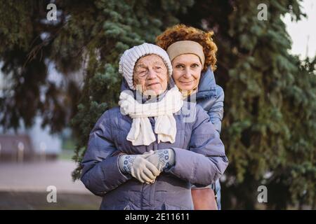 Mutterschaft. Thema Bedeutung Besuch und verbringen Zeit mit alten alleinerziehenden Eltern während der Ferien. Ältere Mutter und reife Tochter glücklich Familie Umarmung und l Stockfoto