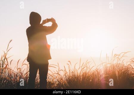 Reisender Mann tragen Pullover nehmen Sie Bilder mit einem Smartphone auf Spitze des Berges Stockfoto