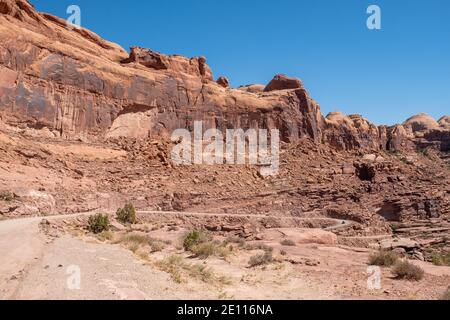 Rote Sandsteinfelsen ragen über der Kane Creek Road, Moab, Utah, USA Stockfoto