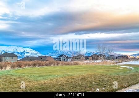 Golfplatz im malerischen verschneiten Tal im Winter mit Häuser Berg und See Stockfoto